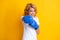 Redhead woman with boxing gloves punching isolated on yellow background