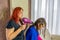 Redhead woman drying her daughter hair after a shower in the living room