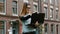 Redhead woman in glasses standing and working on laptop, looking at camera, girl on college background in campus