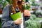 Redhead woman with green plants in hands
