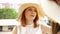 Redhead woman in large summer hat talking to her friend on the balcony