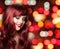 Redhead woman with long curly hairs on bright color party bokeh