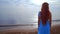 Redhead woman looking at sea. Rear view woman beach. Woman on sea beach