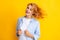 Redhead woman with movement hair. Studio shot of carefree redhead woman smiles cheerfully isolated over vivid yellow