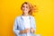 Redhead woman with movement hair. Studio shot of carefree redhead woman smiles cheerfully isolated over vivid yellow