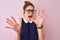 Redhead woman with pigtail wearing elegant dress and glasses over isolated pink background afraid and terrified with fear