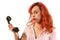 Redhead woman with a retro look speaking at a vintage phone