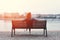 Redhead woman sitting on bench at riverbank in sunset back view