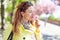 Redhead woman smelling cherry blossom in park during springtime eyes closed