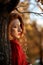 Redhead young woman in a red sweater walks in the park. Autumn beauty portrait of a fashionable Red-haired woman at sunset