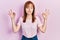 Redhead young woman wearing casual pink t shirt relax and smiling with eyes closed doing meditation gesture with fingers