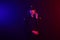 Redheaded female police officer is posing for the camera against a black background with red and blue backlighting.