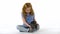 Redheaded little girl with curly hair is gently holding grey chinchilla at white background. Slow motion.