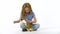 Redheaded little girl with curly hair is stroking fluffy three colored rabbit at white background. Slow motion.