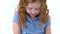 Redheaded little girl with curly hair is stroking grey chinchilla at white background. Slow motion. Close up