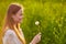 Redheaded teen girl blowing on dandelions