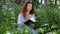 Redheaded woman with notebook in a city park