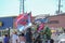 Redneck southern flag and back the blue police flag presenters on a float in the street during Mardi Gras