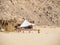 Reed shacks of bedouin village, medium view. Rocky mountain in egyptian desert. Selective soft focus. Blurred background