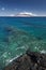 Reef in clear water with view of West Maui Mountains from south shore. Maui, Hawaii, USA