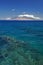 Reef in clear water with view of West Maui Mountains from south shore. Maui, Hawaii, USA