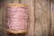 Reel pink yarn left side on wood