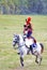 Reenactor dressed as Napoleonic war soldier rides a horse.