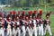 Reenactors dressed as Napoleonic war soldiers march holding guns
