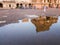 Refection of the entrance tower of the ancient Brihadeeswarar temple in a puddle of