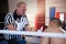 Referee gesturing to male boxer in ring