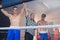 Referee holding hands of smiling male boxing winner by athlete