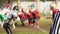 Referee making thumbs-up hand sign, defocused football players on scrimmage line