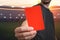 Referee is showing red card as a penalty for a foul in soccer stadium