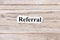 REFERRAL of the word on paper. concept. Words of REFERRAL on a wooden background