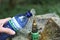 Refilling a plastic water bottle from a tap outdoors at the public park