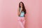 Refined caucasian girl with long hairstyle standing on pink background with smile. Slim blissful brunette woman relaxing