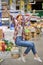 Refined caucasian woman having fun in studio. Relaxed young lady sitting in shopping cart