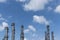 Refinery column with cloudy blue sky.