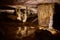 Reflecting waters of stalagmite pair in majestic cave landscape