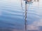 Reflection of a boat mast in the port of Olhao, Algarve region in south of Portugal, at sunset