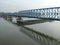 Reflection of bridge on the Danube river with tugboat under