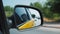 Reflection of city traffic flow in yellow taxi side rear view mirror