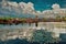 Reflection of the clouds in the lake and the Angkor Wat temple of Cambodia in the background