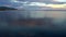 Reflection of evening clouds on the sea surface. The span of the drone above the water. Beautiful northern nature at