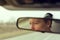 Reflection of female face in car rearview mirror