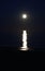 Reflection of the full moon on the placid sea at night