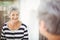 Reflection of happy senior woman on mirror