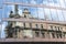 Reflection of a heritage stone structure in a glass building