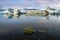 Reflection of ice cubes with moss rock foreground at Jokulsarlon Glacier Lagoon