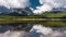 Reflection with lake and mountains low hanging couds in Lower Kananaskis Lake of Peter Lougheed Provincial Park